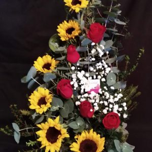 Arreglo en curva de girasoles y rosas