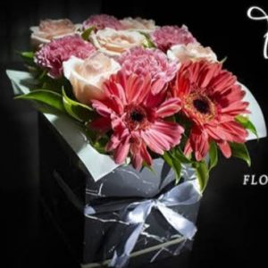 Caja de gerberas, rosas y claveles en la tonalidad